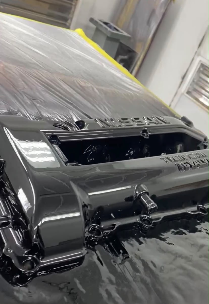 Freshly sprayed glossy black Nissan panel with mirror finish
